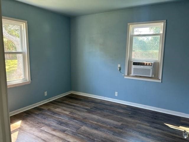 empty room featuring cooling unit and dark hardwood / wood-style flooring