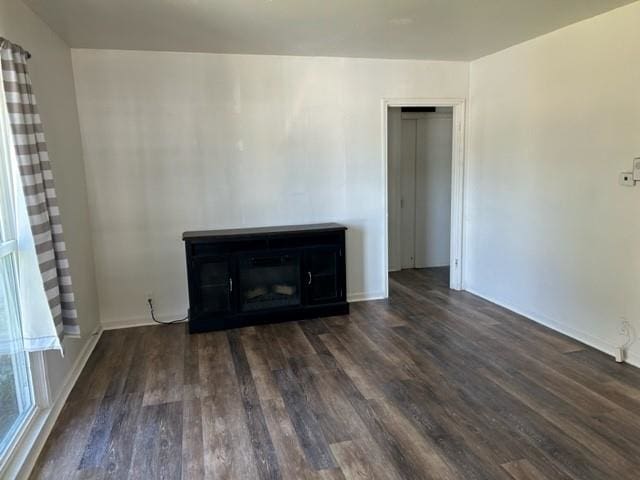 unfurnished living room with dark hardwood / wood-style floors