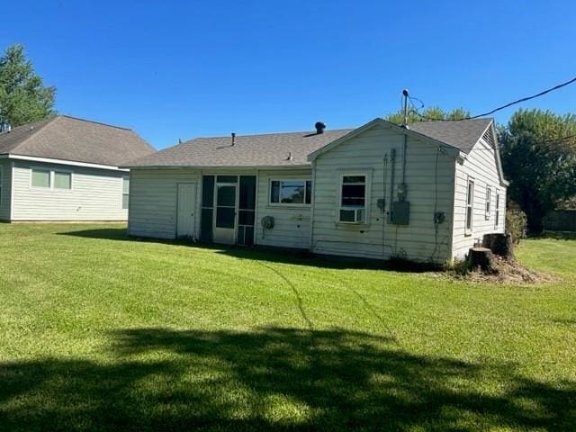 rear view of house with a yard and cooling unit