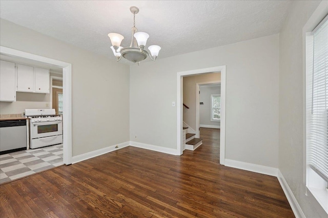 2218 Ashley St, Beaumont, TX 77701 - unfurnished dining area with a chandelier, light wood finished floors, stairway, and a textured ceiling