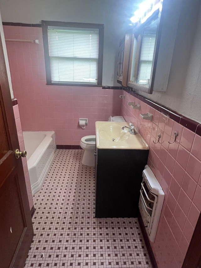 3808 Rachel Ave, Port Arthur, TX 77642 - bathroom featuring tile walls, heating unit, vanity, plenty of natural light, and a wainscoted wall