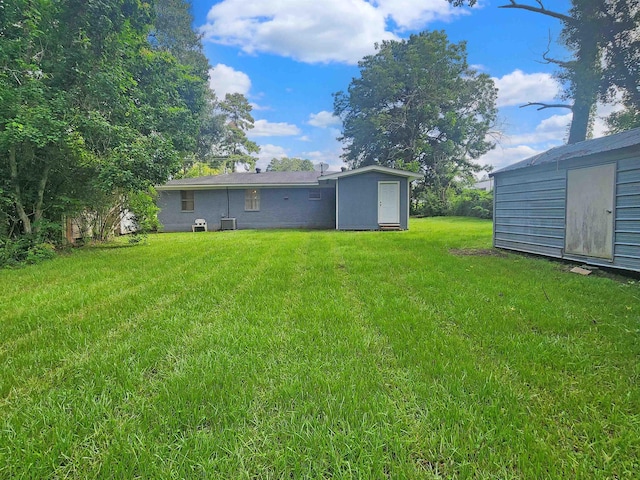 view of yard featuring a storage shed and central AC unit