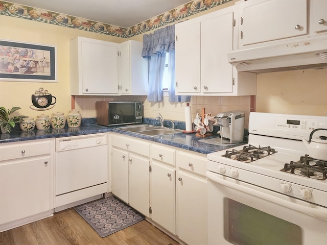 kitchen with white appliances, white cabinetry, sink, backsplash, and light wood-type flooring