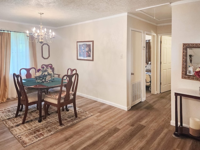 dining area featuring a textured ceiling, a chandelier, ornamental molding, and wood-type flooring