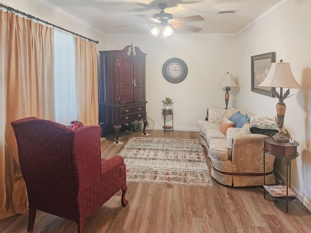 living room featuring ceiling fan, crown molding, and wood-type flooring