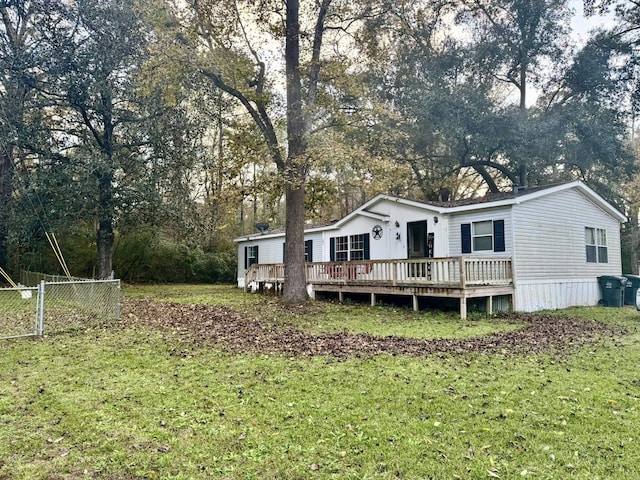 rear view of property featuring a yard and a deck