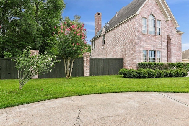 view of side of property with a patio area and a lawn