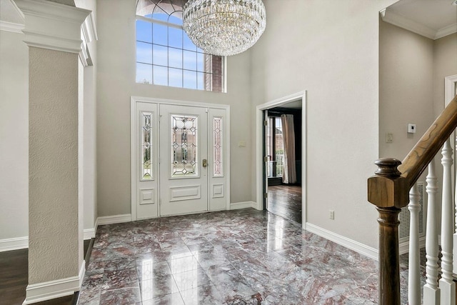 entryway with ornamental molding, a chandelier, and plenty of natural light