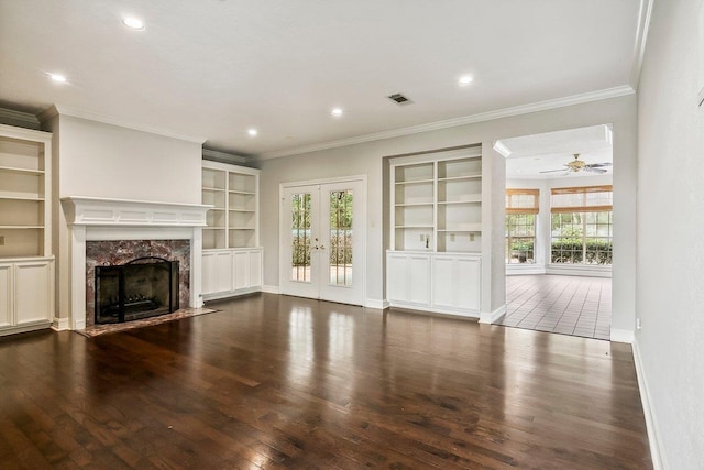 unfurnished living room featuring a premium fireplace, plenty of natural light, and built in features