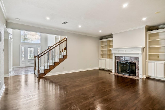 unfurnished living room featuring crown molding, dark hardwood / wood-style floors, built in features, and a high end fireplace