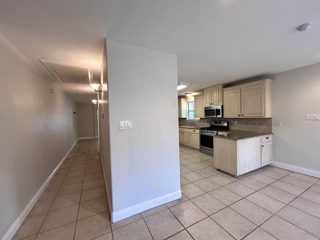 kitchen with decorative backsplash, light tile patterned floors, stainless steel appliances, and sink