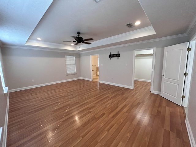 spare room with a raised ceiling, hardwood / wood-style flooring, ceiling fan, and ornamental molding