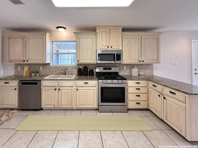 kitchen with decorative backsplash, light tile patterned floors, sink, and appliances with stainless steel finishes