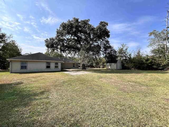 view of yard featuring a patio and a storage shed