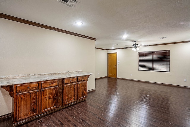 spare room with a textured ceiling, dark wood-type flooring, ceiling fan, and ornamental molding