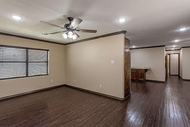 empty room with dark hardwood / wood-style floors, ceiling fan, ornamental molding, and a textured ceiling