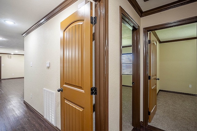 hallway featuring crown molding and dark colored carpet