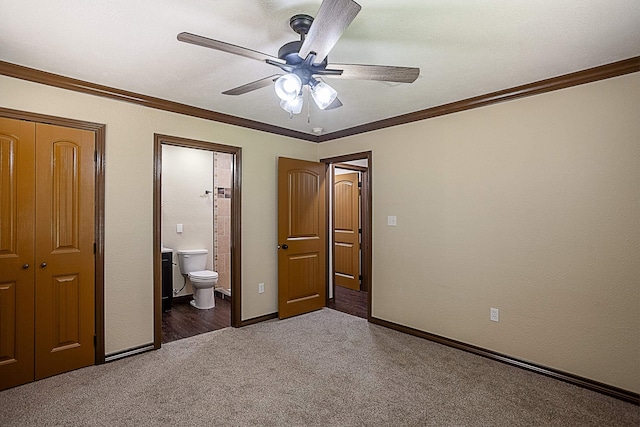 unfurnished bedroom with carpet, ensuite bath, ornamental molding, ceiling fan, and a closet