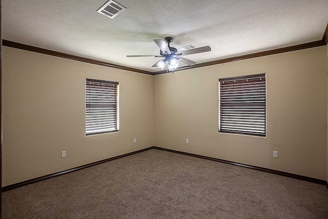 empty room featuring a textured ceiling, carpet floors, ceiling fan, and crown molding