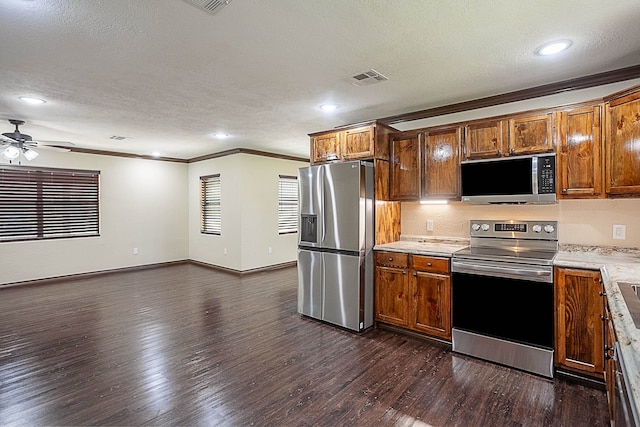 kitchen with ceiling fan, stainless steel appliances, dark hardwood / wood-style flooring, crown molding, and a textured ceiling