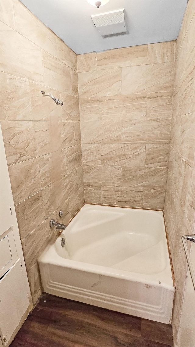 bathroom featuring visible vents, wood finished floors, and shower / bathing tub combination