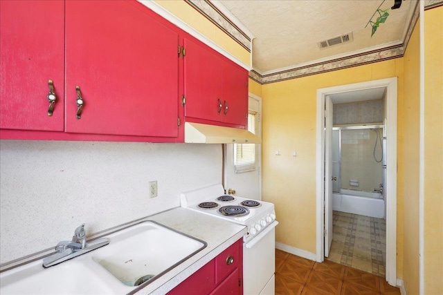 kitchen featuring white electric stove, red cabinetry, and under cabinet range hood