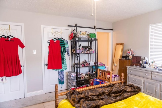 bedroom with light tile patterned flooring and a textured ceiling