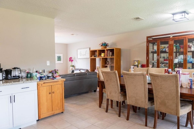 dining room with light tile patterned floors and a textured ceiling