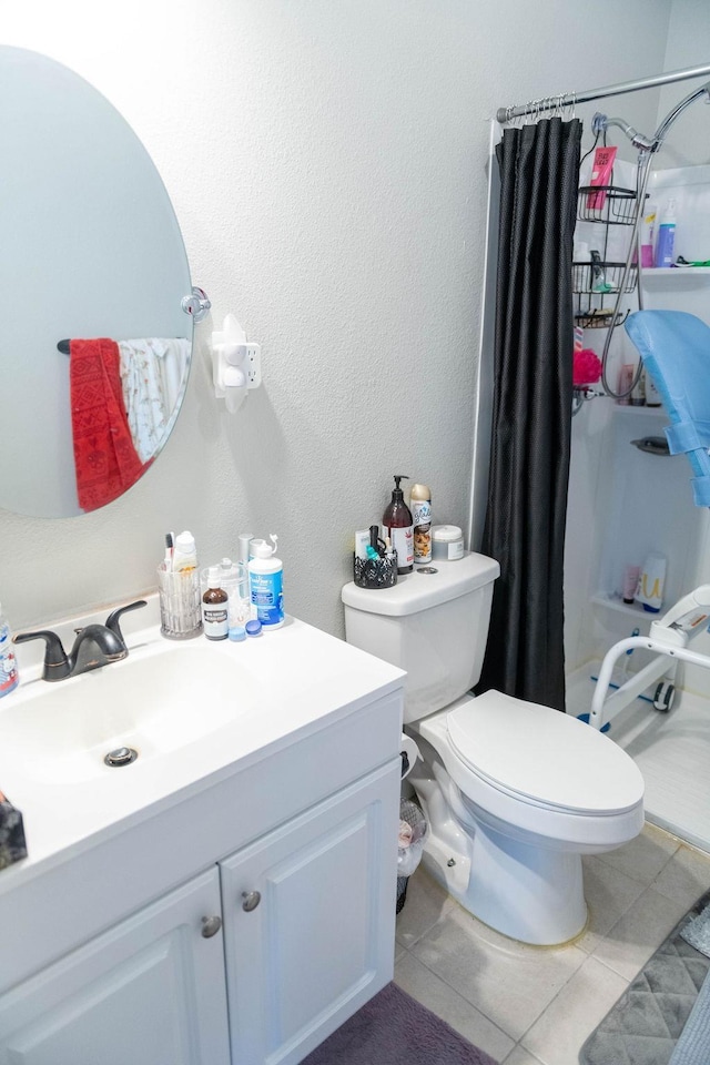 bathroom featuring tile patterned floors, vanity, toilet, and walk in shower