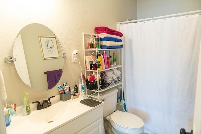 bathroom featuring vanity, toilet, and curtained shower