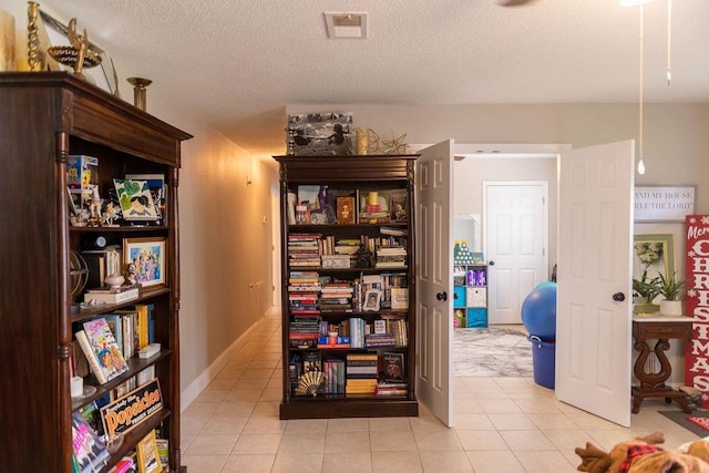 interior space with light tile patterned floors and a textured ceiling