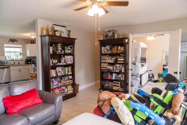 living room with a textured ceiling, ceiling fan, and light tile patterned flooring