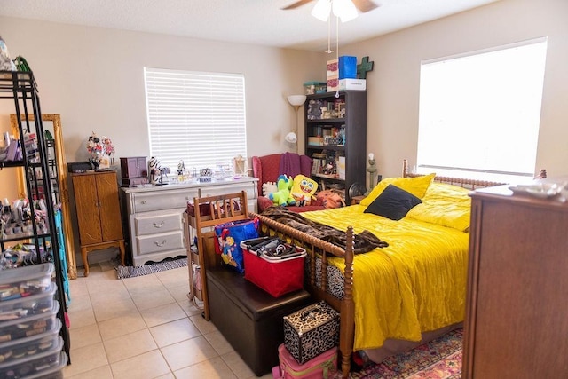 tiled bedroom with ceiling fan and multiple windows