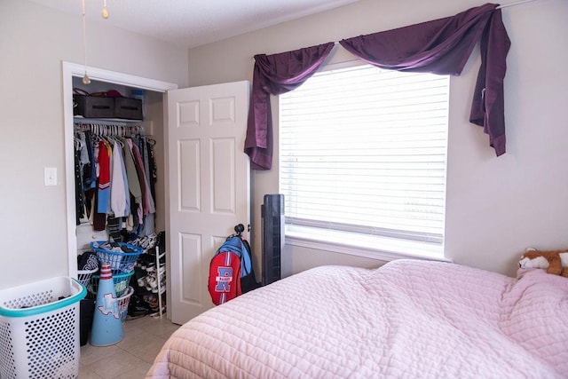 bedroom with light tile patterned floors and a closet