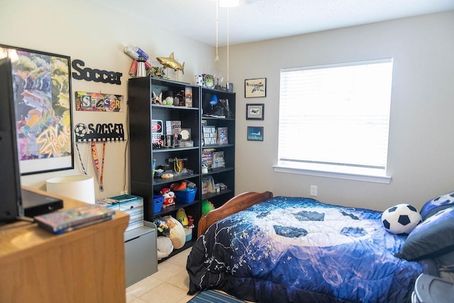 bedroom with light tile patterned floors and multiple windows