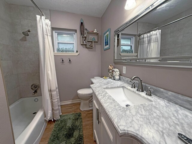 330 Hillcrest Dr, Lumberton, TX 77659 - full bathroom with toilet, vanity, shower / bathtub combination with curtain, a textured ceiling, and wood finished floors