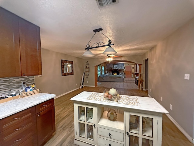 330 Hillcrest Dr, Lumberton, TX 77659 - kitchen featuring a ceiling fan, tasteful backsplash, glass insert cabinets, light wood-style flooring, and open floor plan