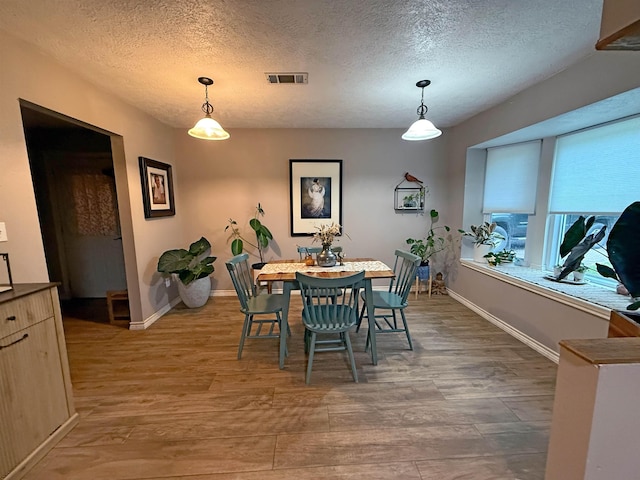 330 Hillcrest Dr, Lumberton, TX 77659 - dining room with light wood-type flooring, a textured ceiling, and baseboards