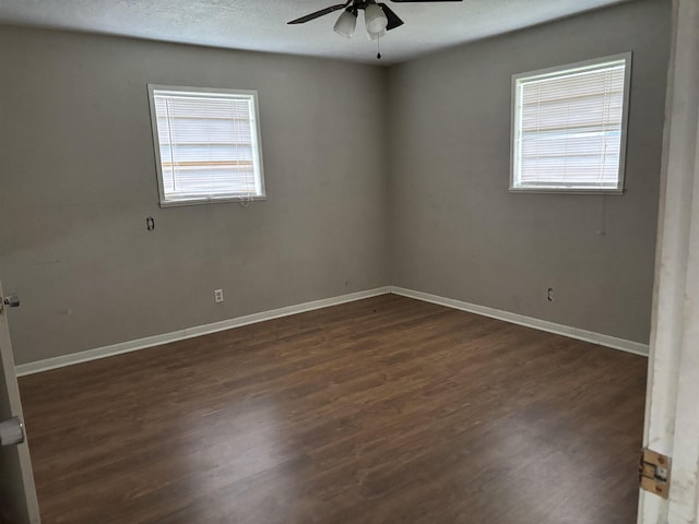 spare room with ceiling fan and dark wood-type flooring