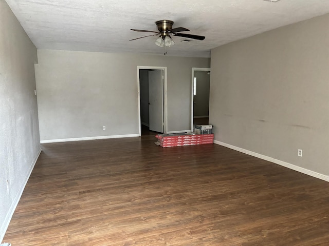 spare room featuring dark hardwood / wood-style floors, ceiling fan, and a textured ceiling