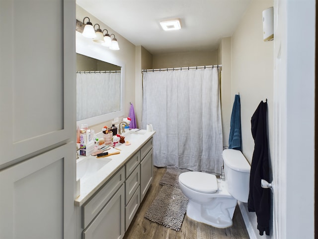 bathroom featuring wood-type flooring, vanity, and toilet