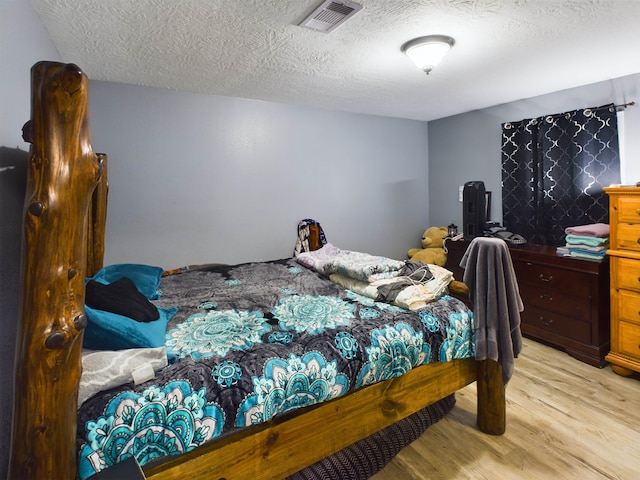 bedroom featuring a textured ceiling and light wood-type flooring