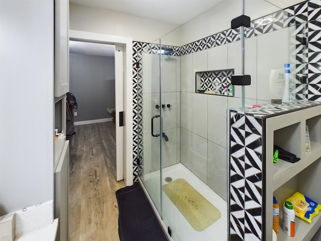 bathroom with wood-type flooring and an enclosed shower