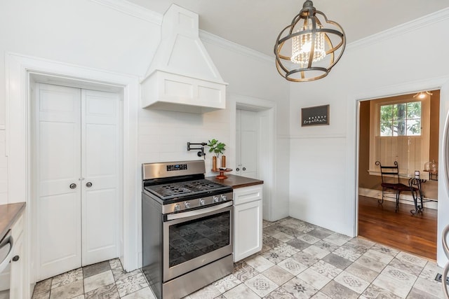 kitchen with gas range, white cabinetry, ornamental molding, and a notable chandelier