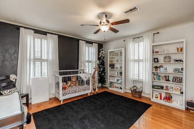 bedroom featuring ceiling fan, hardwood / wood-style floors, and ornamental molding