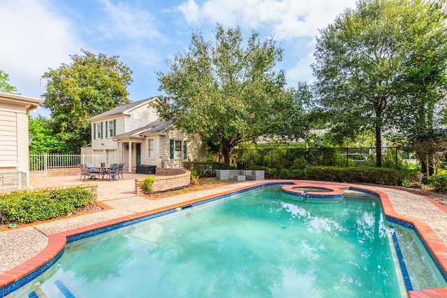 view of swimming pool featuring an in ground hot tub and a patio