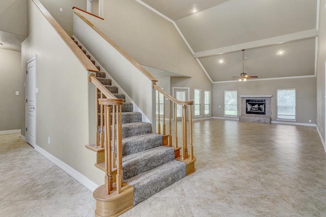 stairs with ceiling fan and high vaulted ceiling