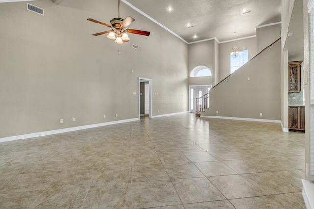 unfurnished living room featuring a high ceiling, ceiling fan with notable chandelier, light tile patterned floors, and ornamental molding