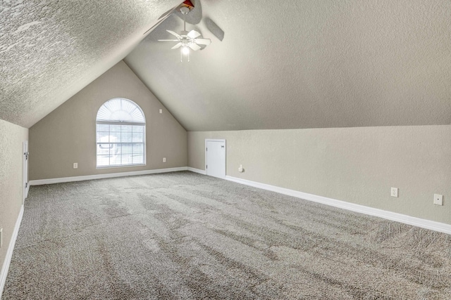 additional living space with carpet flooring, ceiling fan, lofted ceiling, and a textured ceiling