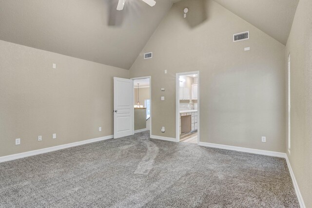 unfurnished bedroom with carpet floors, connected bathroom, ceiling fan, and high vaulted ceiling